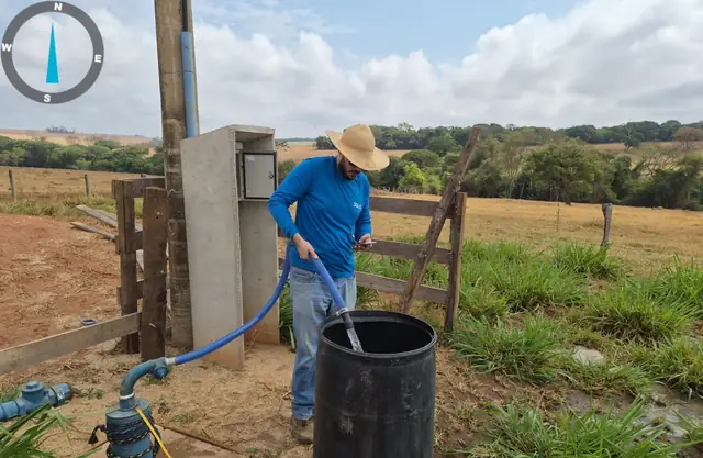 Aferição da vazão de um poço tubular com mangueira e tambor durante o teste de bombeamento